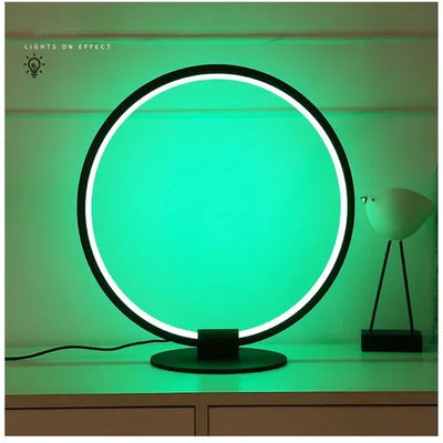 Moderne runde LED-Tischleuchte mit grünem Licht auf weißem Regal, dekoratives Design